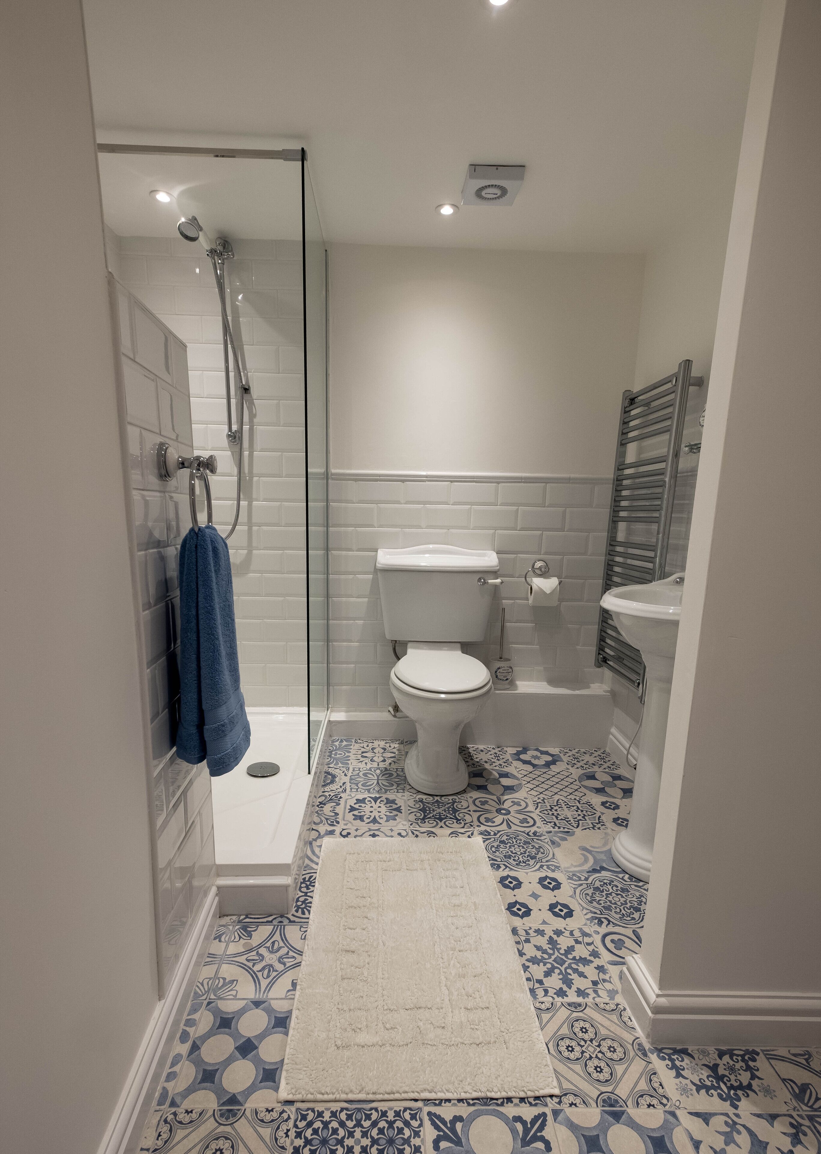 Un bagno con doccia vetrata, un water e un lavandino.