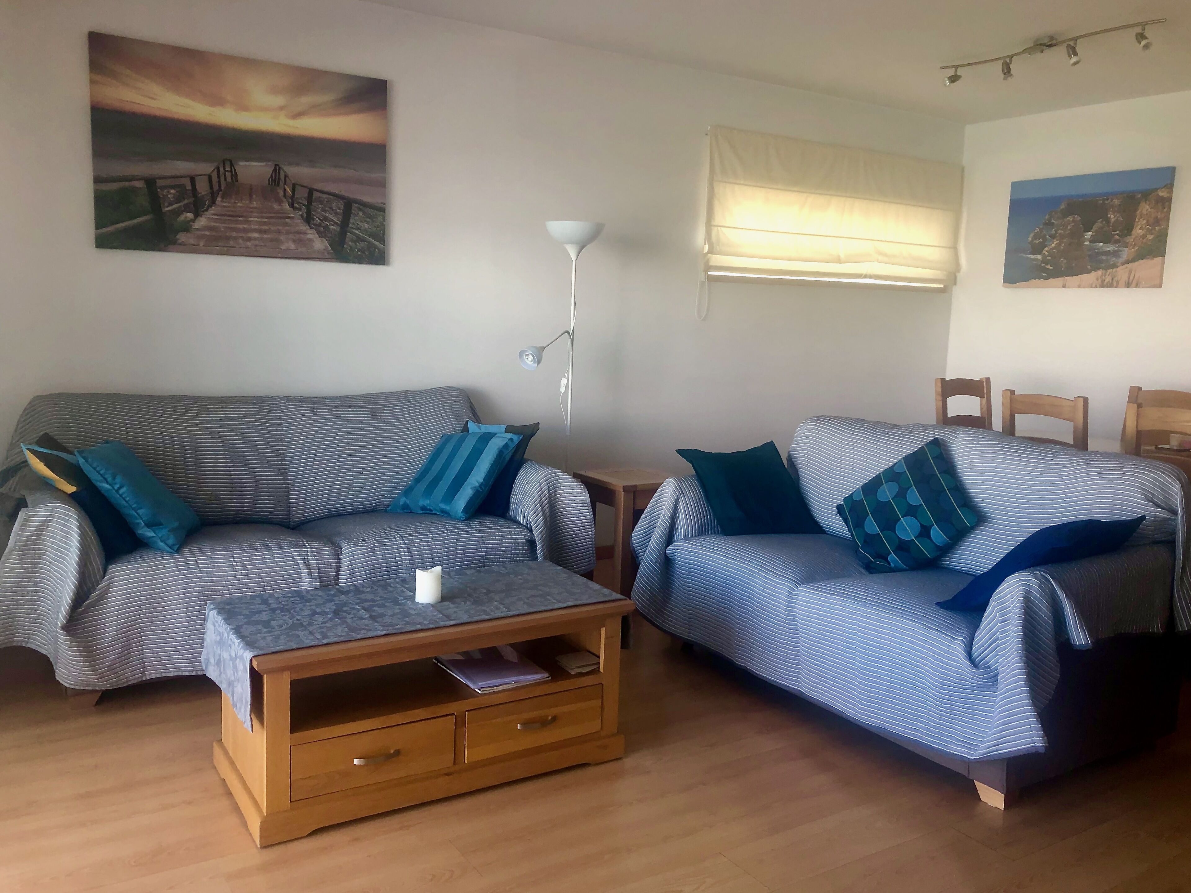A living room with two striped sofas, a wooden coffee table, and a lamp.