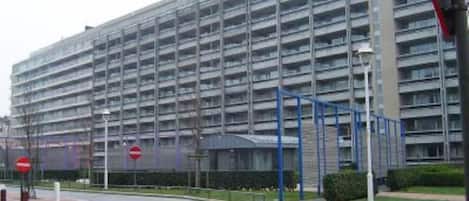 A multi-story parking garage with a modern design, featuring a grid of parking spaces and a covered pedestrian walkway.