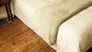 A neatly made bed with white linens and a fluffy beige throw blanket, a wooden nightstand with a lamp, and a mirror on the wall. - St Malo F3 62m² Alet Solidor peninsula, sea 50m, wifi, garden, secure parking (ST MALO)