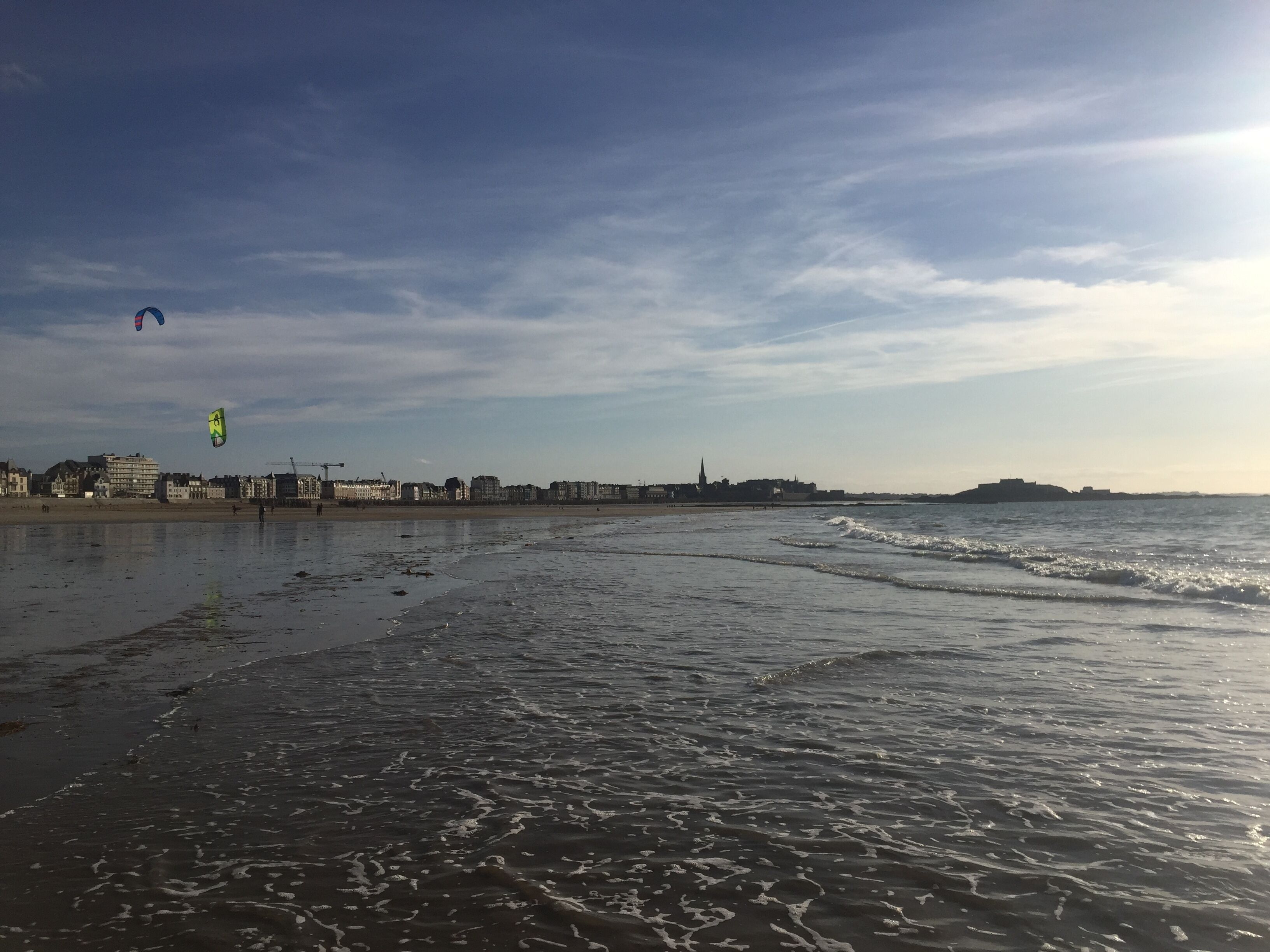 Ein Strand mit Blick auf Gebäude in der Ferne.