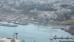 A coastal town with a marina, buildings, and a prominent tower. - ONLY 150 METERS FROM THE SEA OF S. SALENTO- MARIA DI LEUCA- PESCOLUSE-Torrevado (Leuca)