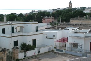 Un quartier résidentiel avec des bâtiments blancs, un escalier rouge et une tour en arrière-plan.