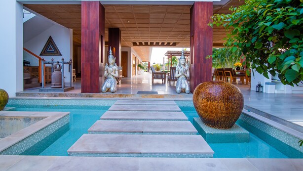 A pool area with a large decorative vase, two statues, and a view into the building. - Golf Resort /Villa in Hua Hin, Palm Hills Golf Resort (Tambon Hua Hin)