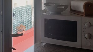 Una cocina con microondas, un bol y un rollo de papel de cocina en la encimera.