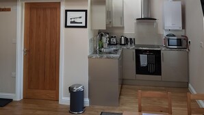 Eine Küche mit Holzbalken, einer Mikrowelle, einem Toaster und einem Spülbecken.