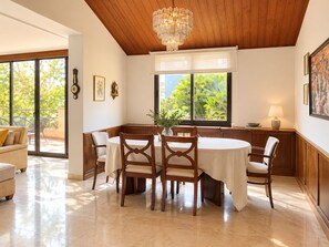 A dining area with a round table, chairs, and a chandelier. - Large house with private pool and garden n Begur for 12 guests (Begur)