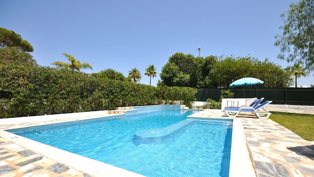 A rectangular swimming pool with tiled edges, surrounded by a stone patio. - Delightful single-storey villa, private pool, free air conditioning and wifi (Vilamoura)