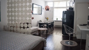 Ett modernt hotellrum med en säng, ett matbord, en stol och en tv.