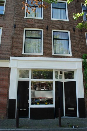 A two-story brick building with a white-framed window display at the ground level.