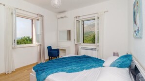 Une chambre à coucher avec un lit, un bureau et deux fenêtres.