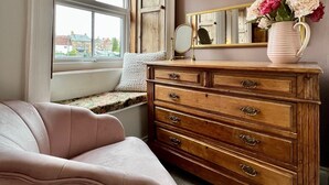 A bedroom with a window, a dresser, a mirror, and a chair. - Luxury character Cottage in a popular Village location in Central Northumberland (Morpeth)