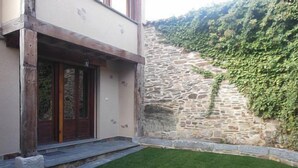 A modern building with a stone wall and a well-maintained lawn. - Aunt Matea's House for 7 people (Migueláñez)