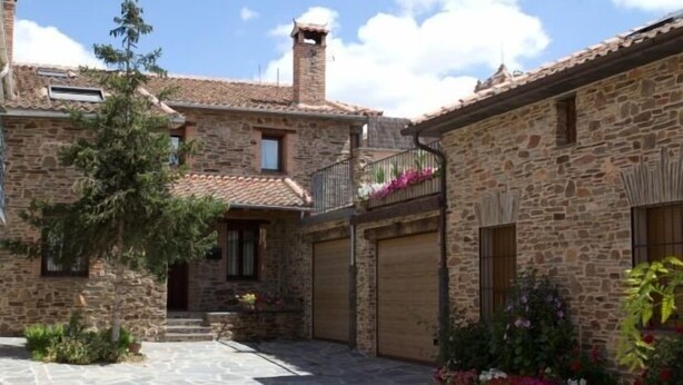 A stone building with a courtyard, featuring a staircase, a small tree, and flower beds. - Aunt Matea's House for 7 people (Migueláñez)
