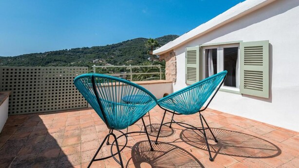 Eine Terrasse mit zwei Stühlen und Blick auf eine Hügellandschaft.