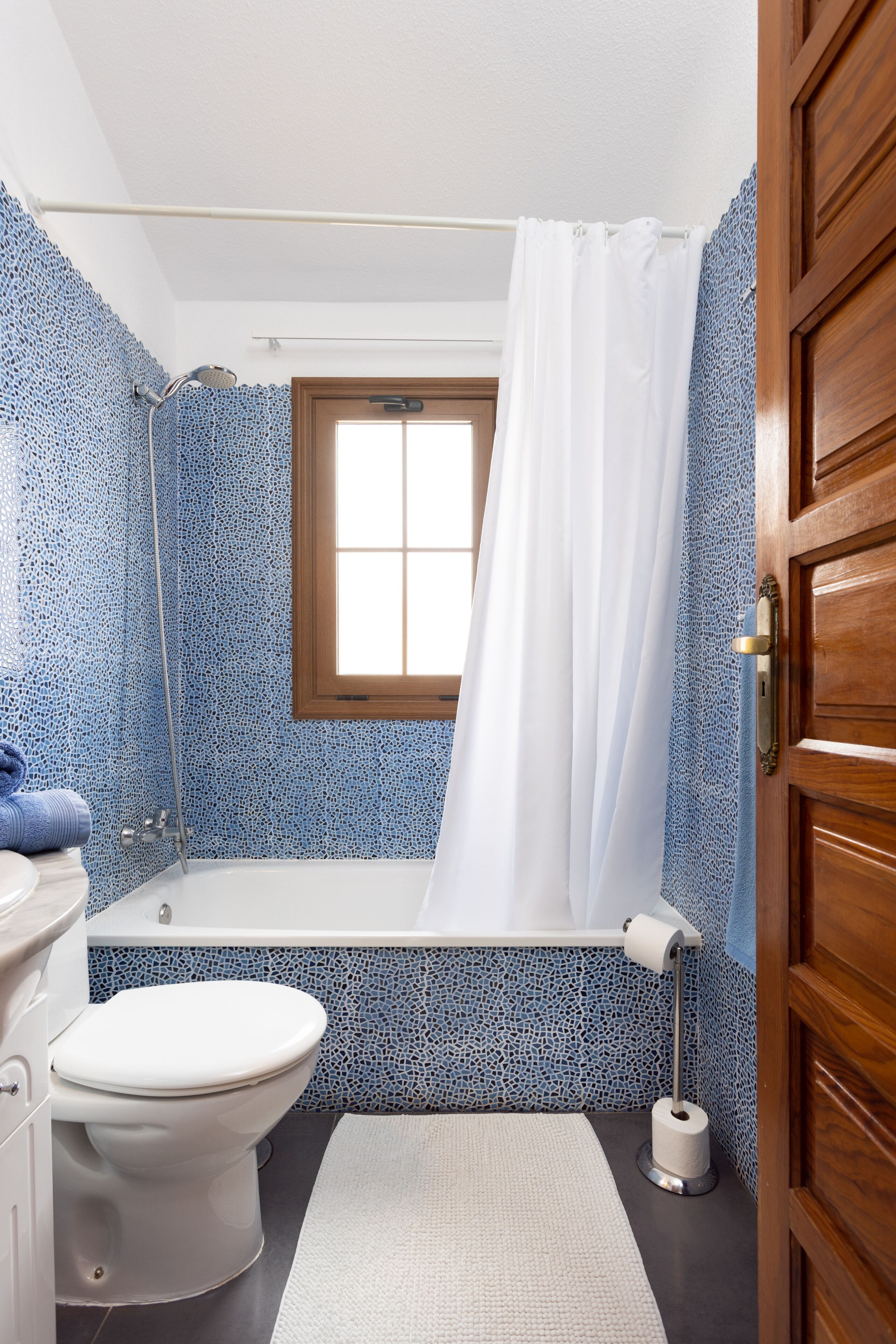 Un baño con bañera, inodoro y ducha.