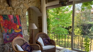 A cozy balcony with wicker chairs, a mosaic table, and a painting on the wall. - Lovely Old Stone Bastide With Private Pool, Short Drive To Beach (Vence)