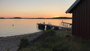 A wooden pier extending into calm water with a small dock and a bench. - Wonderful house in Strömstad! (Strömstad)