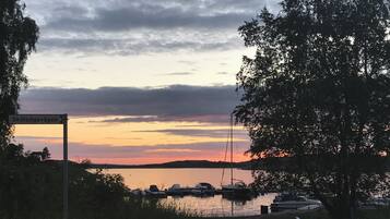 A marina with boats docked, a sign indicating parking for boats, and a cloudy sky.