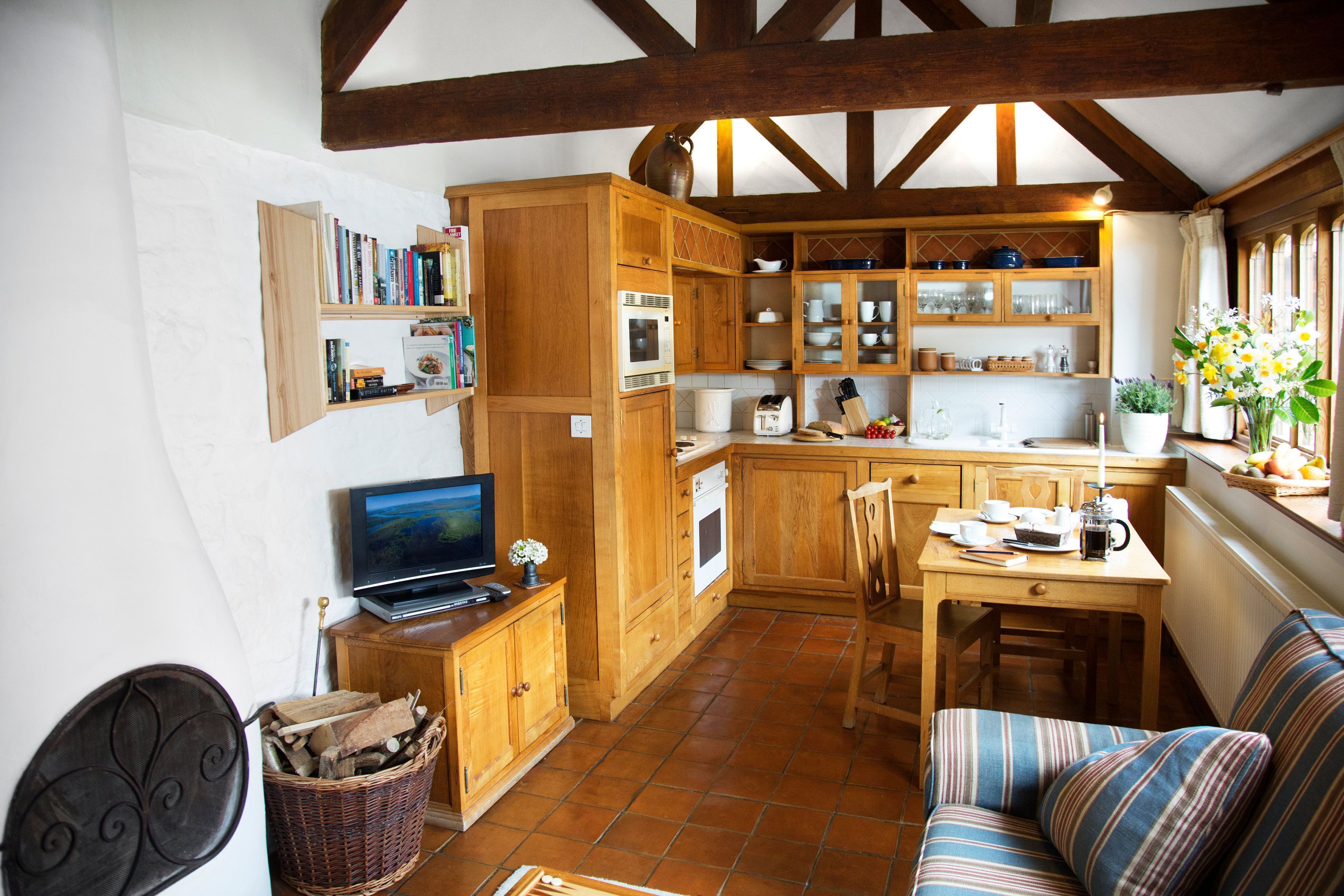 A cozy kitchen with wooden cabinets, a dining table, and a sofa.