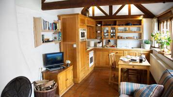 A cozy kitchen with wooden cabinets, a dining table, and a sofa.