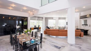 A spacious living area with a modern kitchen, a dining area with a glass table, and a large window providing natural light. - Stunning villa for private Escape/ Create priceless memories! large private pool (Hania)