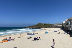 A beach with tents, umbrellas, and people relaxing.