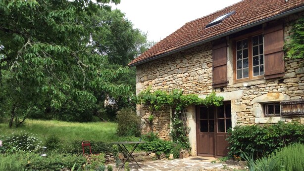 A stone house with a tiled roof, a wooden door, and a small garden with a stone pathway. - NEW: Barn conversion in a fantastic village in the Lot (Limogne-en-Quercy)