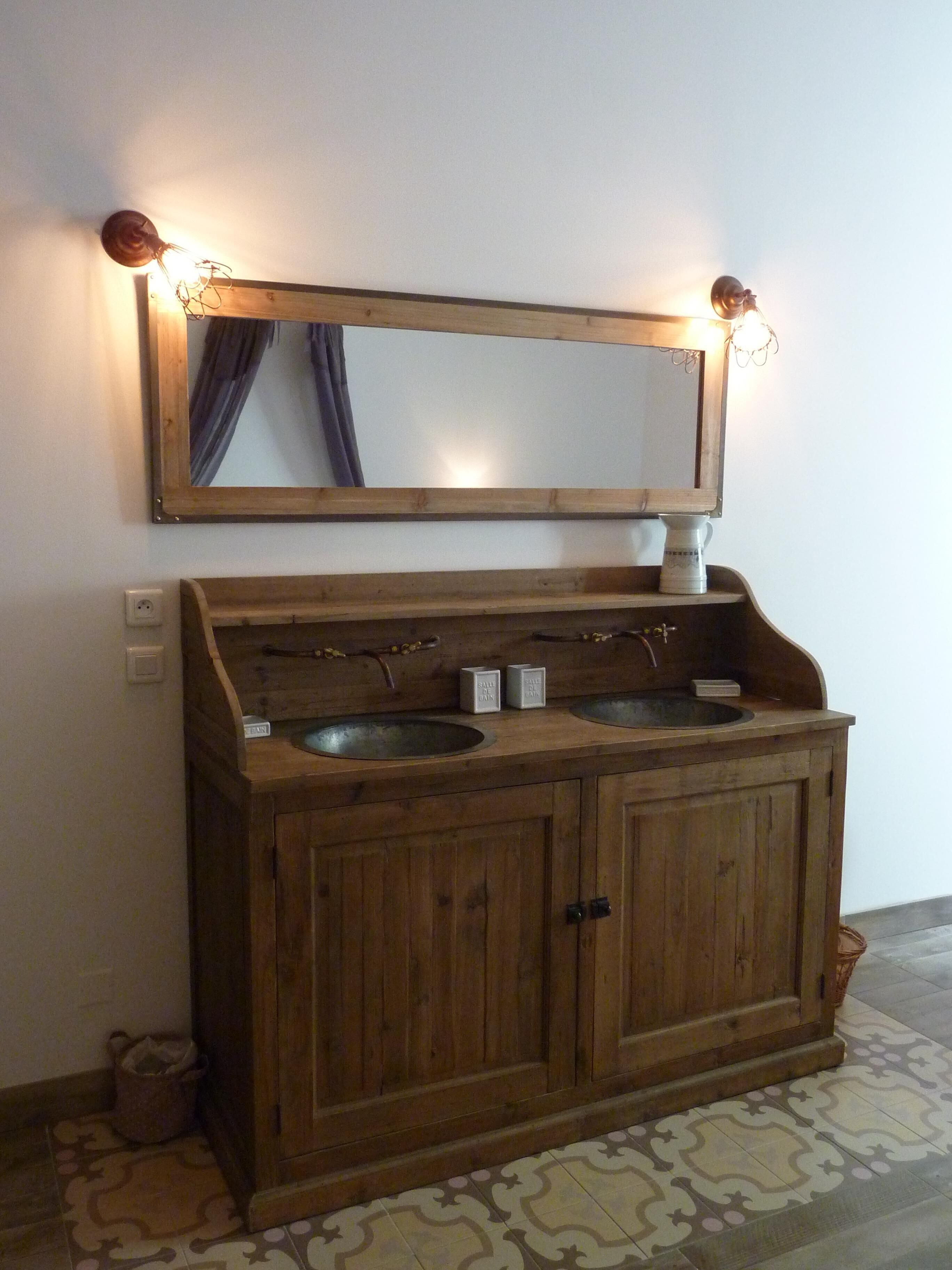 Ein Holzbettplatz mit zwei Waschbecken und einem Spiegel darüber.