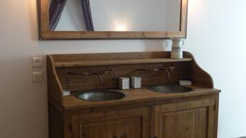 Ein Holzbettplatz mit zwei Waschbecken und einem Spiegel darüber.
