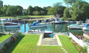 A marina with boats docked, a well-maintained lawn, and a view of the surrounding area.