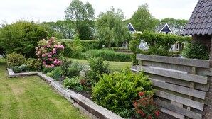 A garden with various plants and a wooden fence.