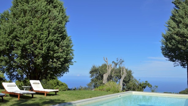 A poolside area with two lounge chairs and a clear view of the ocean. - House with pool, sea views near Cefalu and Castelbuono and beach 10 minutes (Pollina)