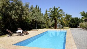 Una piscina rectangular con superficie de agua azul cristalina, rodeada por un borde de ladrillo.