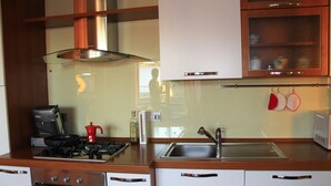 Una cocina con estufa, fregadero y armarios.