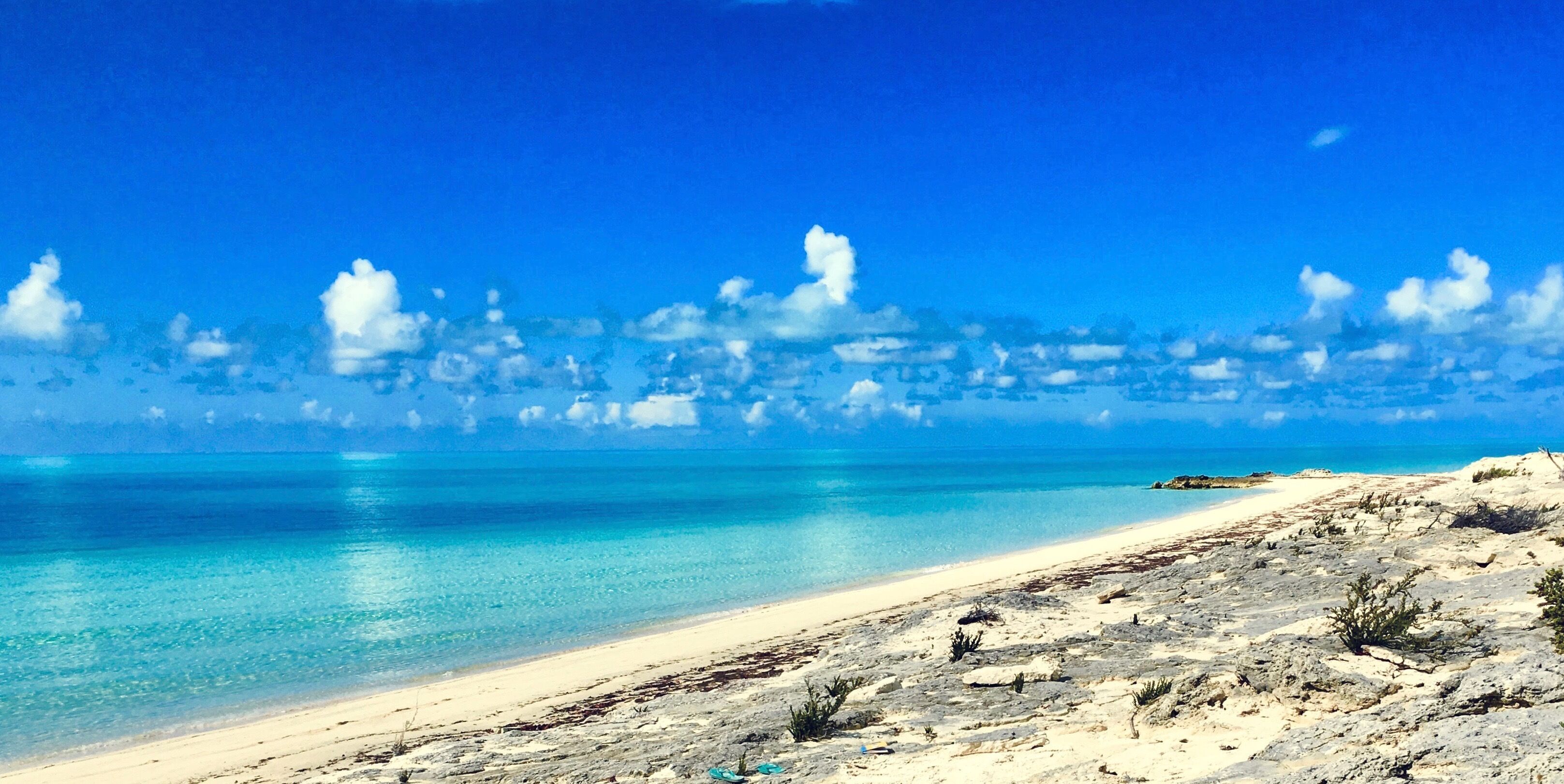 Ein Strand mit klarem türkisblauem Wasser und einem Sandufer.