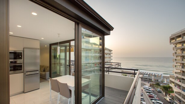 A modern apartment with a balcony overlooking the sea, a kitchen, and a dining area. - PREMIUM 3 BEDROOMS PENTHOUSE BEACHFRONT IN TORREMOLINOS  (Torremolinos)