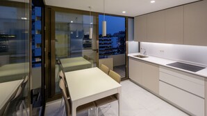 A modern kitchen with a dining area, large windows, and a view of the cityscape. - PREMIUM 3 BEDROOMS PENTHOUSE BEACHFRONT IN TORREMOLINOS  (Torremolinos)