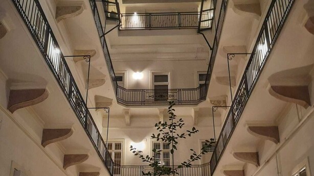 A multi-level atrium with a central garden, balconies, and a staircase. - Kis Aldebaran Apartment: a little jewel in the center !! (Budapest)