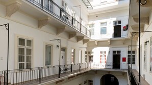 A multi-level courtyard with balconies, a central garden, and a staircase leading to an upper floor. - Kis Aldebaran Apartment: a little jewel in the center !! (Budapest)