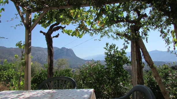 Una mesa con mantel estampado de lunares, una silla y una vista de montañas al fondo.