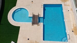Vista aérea de uma piscina com uma área circular afundada e uma piscina retangular separada.