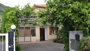 Een huis met een hek, een klein portaal en een garage.