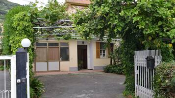 Una casa con cancello, un piccolo portico e un garage.