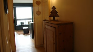 Ein Flur mit Heizkörper, Holzschrank und Wandleuchte.