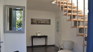 A room with a staircase, a chair, a table, and a framed picture on the wall. - ARRAS BEAUTIFUL HOUSE, LARGE TERRACE WITH VIEW ON VERY NICE PARK (Arras)