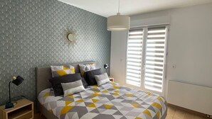 A bedroom with a bed, a nightstand, a lamp, and a window with blinds. - ARRAS BEAUTIFUL HOUSE, LARGE TERRACE WITH VIEW ON VERY NICE PARK (Arras)