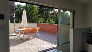 A modern room with a sliding glass door leading to an outdoor patio with a table and chairs. - ARRAS BEAUTIFUL HOUSE, LARGE TERRACE WITH VIEW ON VERY NICE PARK (Arras)
