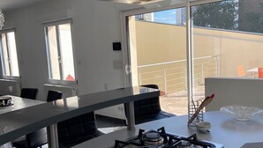 A modern kitchen with a gas stove, a large window, and a balcony. - ARRAS BEAUTIFUL HOUSE, LARGE TERRACE WITH VIEW ON VERY NICE PARK (Arras)