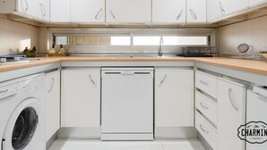 A modern kitchen with white cabinetry, a dishwasher, and a washing machine. - Eurobuilding 2 Exclusive - Spectacular views, parking (Madrid)
